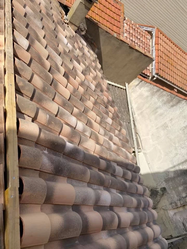 Pose des nouvelles tuiles sur une toiture à Pomérols